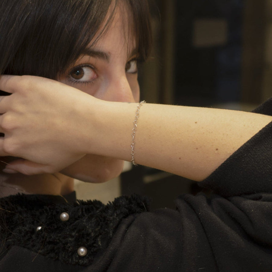 Immagina un bracciale delicato e leggero, composto da una fila di piccoli cuori, questo bracciale è realizzato con un sottile filo d’argento, lucido e liscio al tatto. Il design è semplice ma ricco di significato, ideale per chi ama dettagli raffinati e romantici. Il bracciale, venduto dal nostro laboratorio orafo a Livorno, scivola dolcemente sul polso, regalando una sensazione di leggerezza e una carezza che accompagna ogni movimento.