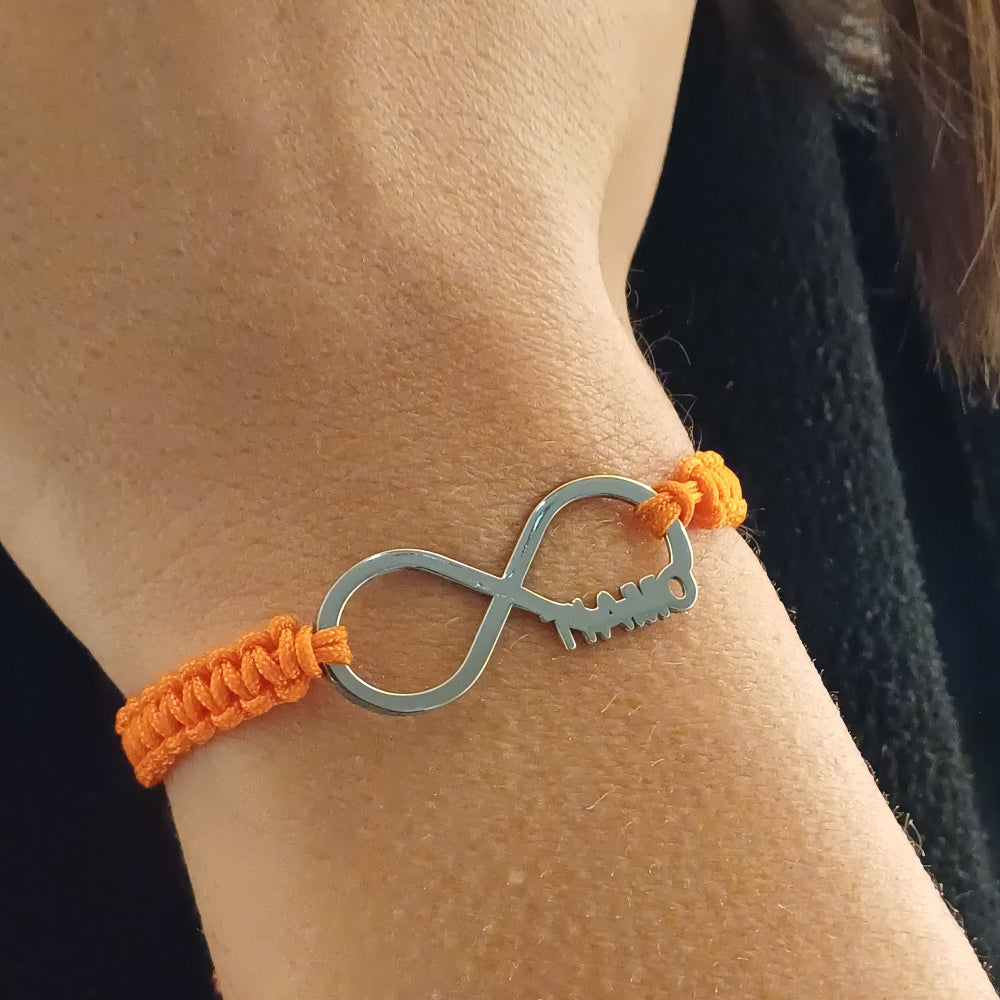 Il bracciale ha un design minimal ed elegante: un simbolo dell'infinito in argento 925 dal profilo liscio e brillante. Su un lato del simbolo, la scritta "Ti Amo" è delicatamente intagliata. Il bracciale è legato con un laccio in corda arancione intrecciata, che aggiunge un tocco vivace. Il contrasto tra il metallo freddo e la texture morbida del laccio lo rende piacevole da indossare, leggero ma resistente. Perfetto per chi ama i gioielli slim e personalizzati.