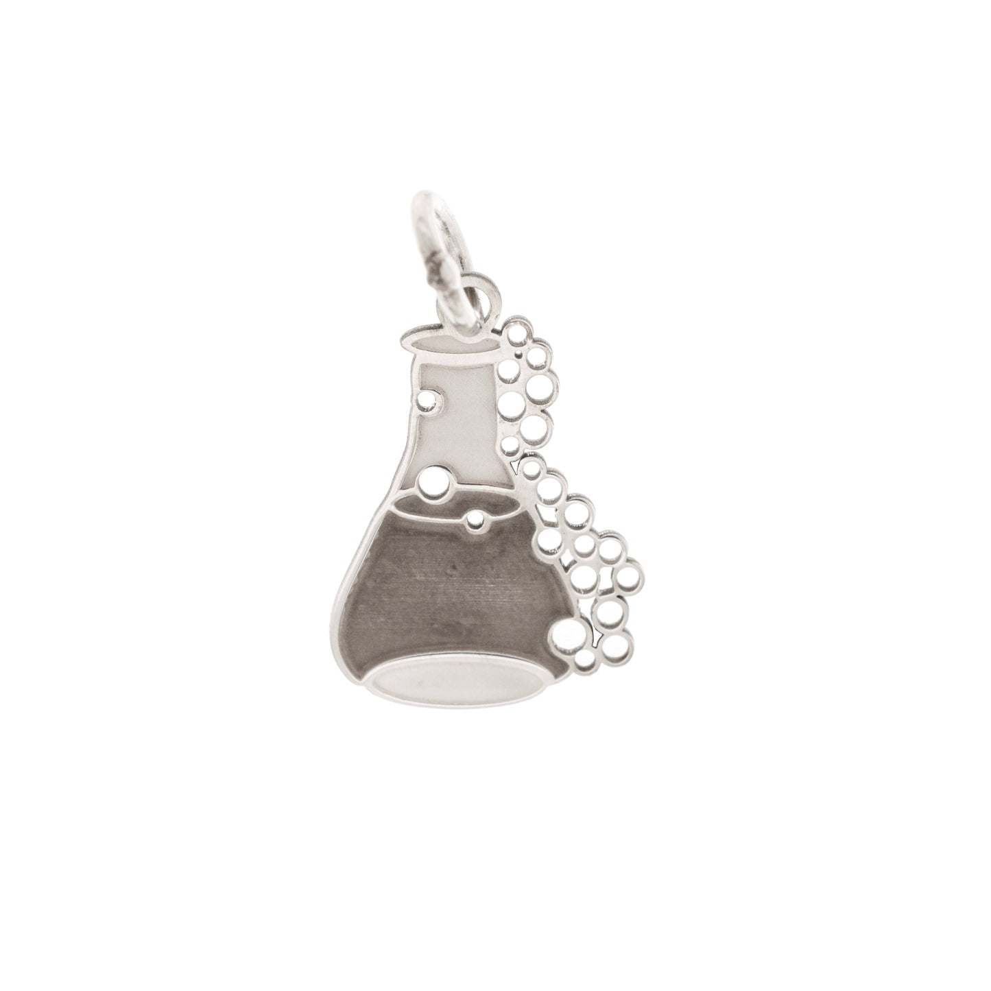 Il ciondolo rappresenta una piccola ampolla da laboratorio, alta circa 1,3 cm, realizzata in argento 925. La superficie è liscia e satinata, con rilievi che rappresentano delle bollicine che sembrano salire lungo il bordo. L’oggetto è leggero, con forme morbide e linee dolci. Al tatto, le bolle e il bordo dell’ampolla offrono una piacevole variazione tra pieno e vuoto, rendendolo facile da riconoscere e molto evocativo.