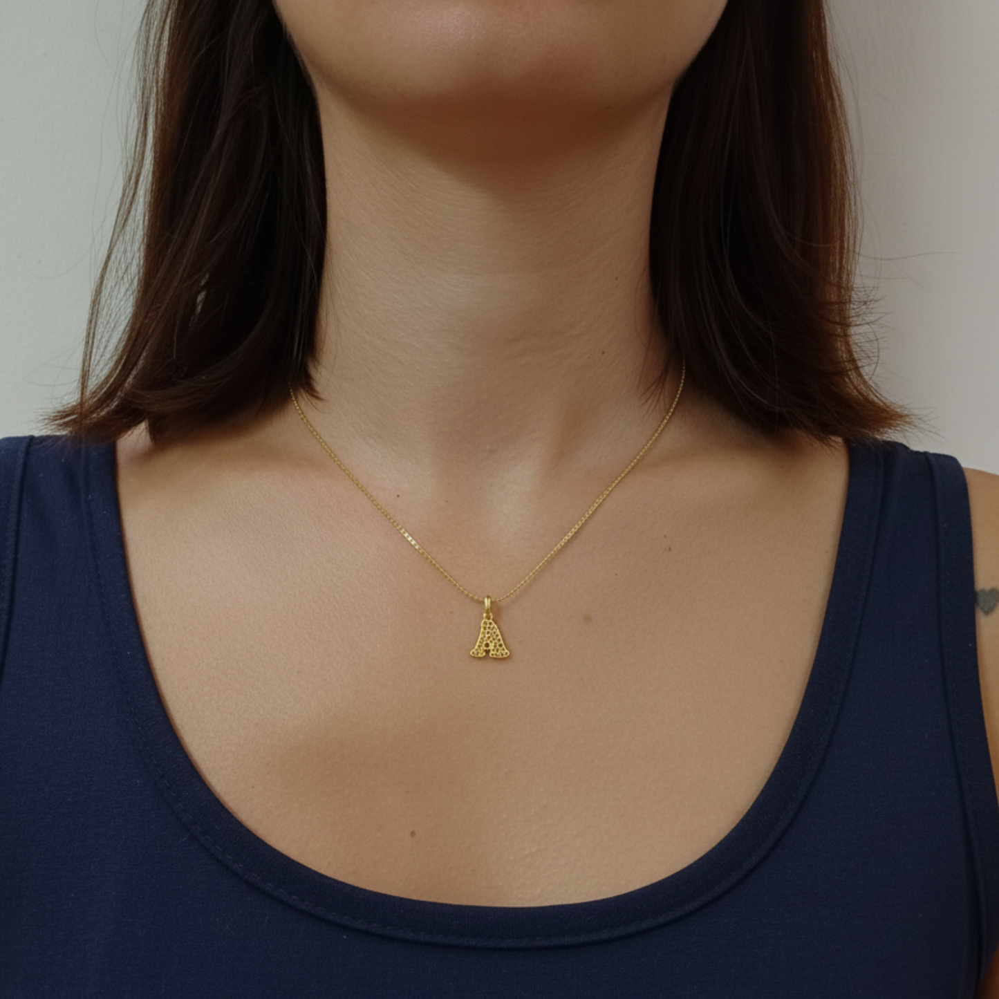 Ciondolo in oro a forma di lettera personalizzabile. Design traforato moderno e luminoso, prezzo 40 €.