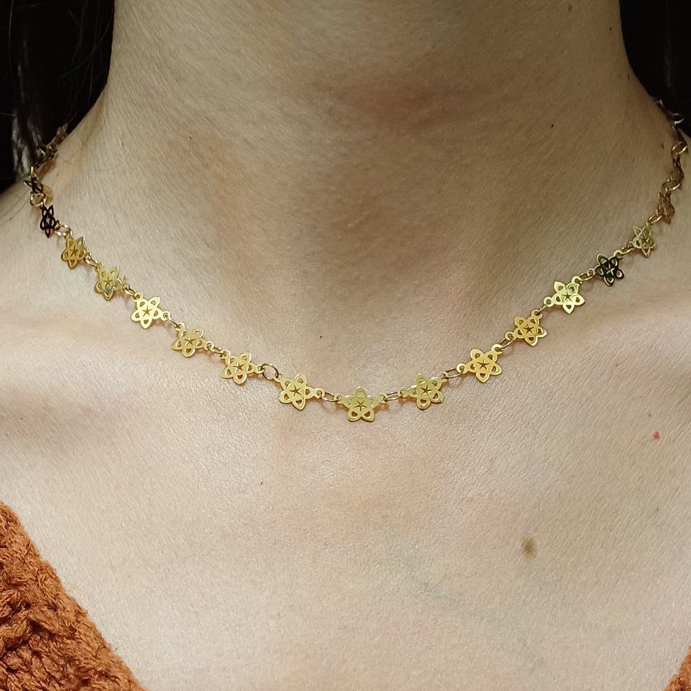 Questo girocollo in oro è un intreccio raffinato di piccoli fiori traforati, uniti tra loro per formare una catena leggera e delicata. Il metallo, dal colore caldo e brillante, riflette la luce con eleganza. Il tocco è liscio e sottile, ma la lavorazione artigianale aggiunge una sensazione di autenticità e unicità. Il girocollo è realizzato con taglio laser e rifinito a mano, unendo tradizione e innovazione nel nostro laboratorio orafo a Livorno.