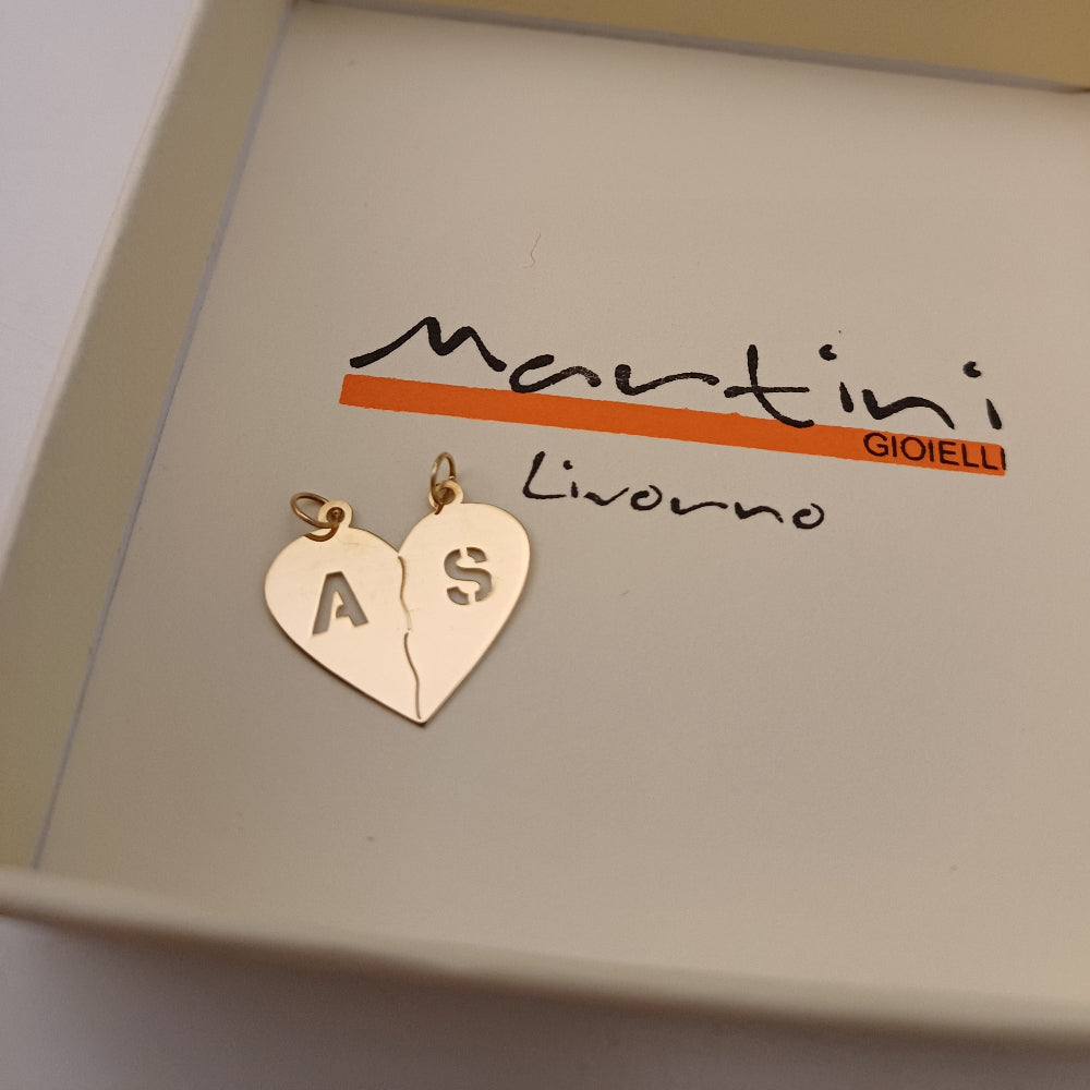 Il ciondolo è un cuore d’oro diviso in due, pensato per essere spezzato e condiviso. La superficie è liscia e levigata, mentre le iniziali traforate creano un raffinato gioco di pieni e vuoti. Ogni metà è leggera e si adatta perfettamente a una collana. Questo gioiello personalizzato rappresenta un legame speciale, che si porta sempre con sé, diviso ma mai separato.