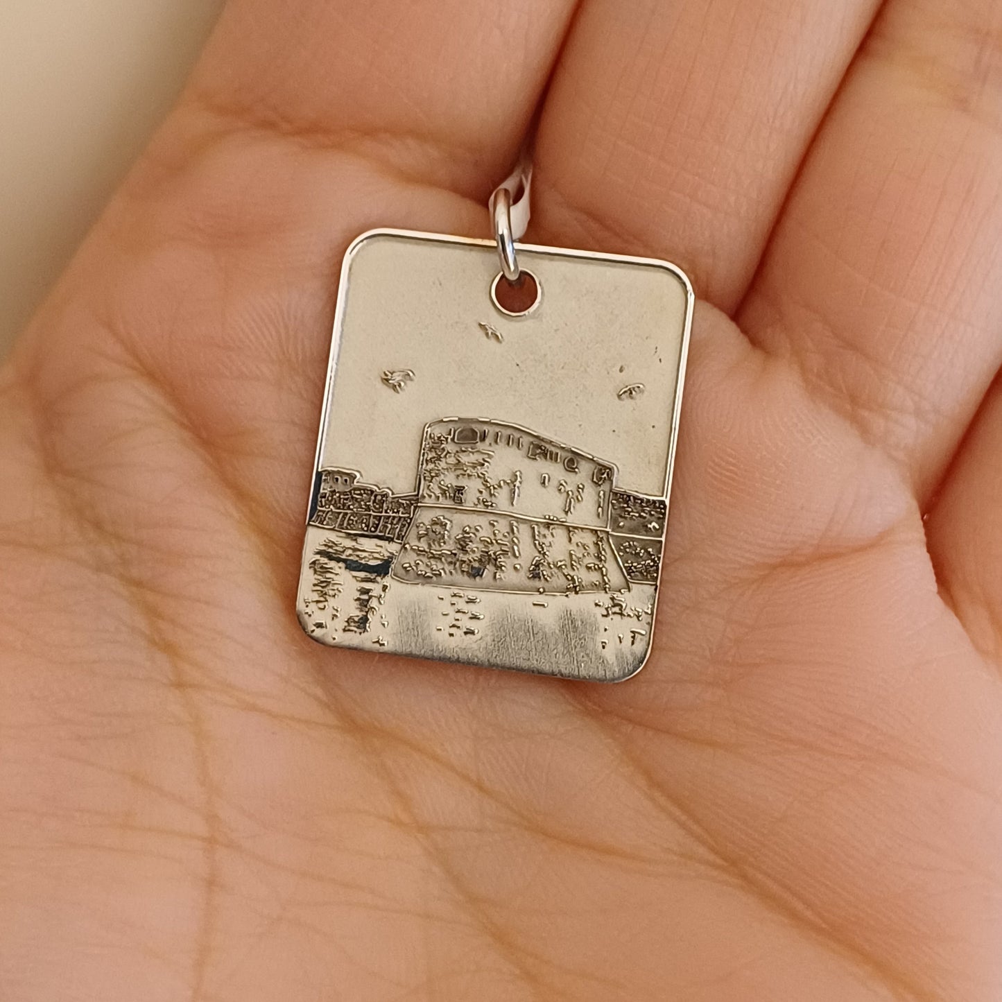 Medaglia rettangolare in argento 925/°°°, realizzata a mano e incisa a laser. Raffigura la Fortezza Vecchia di Livorno con linee precise e dettagliate. Misura 25x20 mm. La superficie è lucida, il bordo leggermente smussato. Adatta come pendente per collana o come piccolo oggetto simbolico. Gioiello artigianale, pensato per chi ama Livorno o vuole portare con sé un ricordo autentico. Personalizzabile sul retro con un’incisione su richiesta.