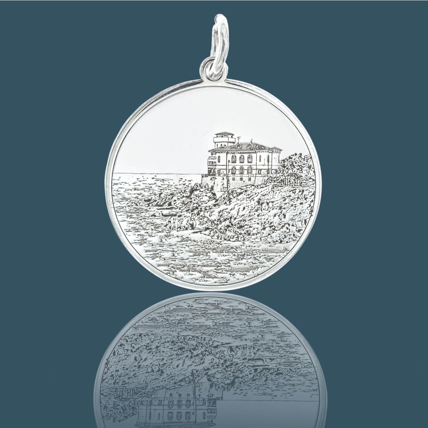 Il pendente Castel Boccale in argento 925 è un gioiello realizzato a mano da un laboratorio orafo a Livorno. Raffigura il maestoso Castel Boccale, simbolo della costa livornese, con dettagli precisi ottenuti tramite incisione laser. La superficie è liscia al tatto con un rilievo che richiama il paesaggio marino. Un gioiello che unisce artigianato e bellezza, ideale per chi cerca un legame tangibile con Livorno e il suo fascino unico.