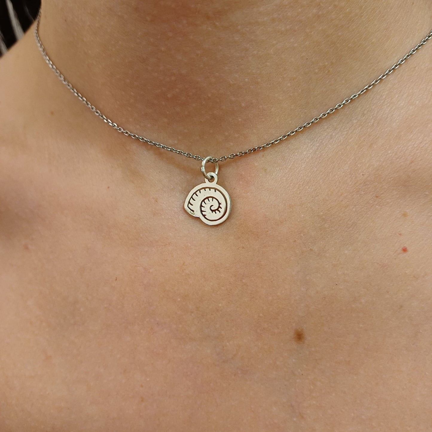 Questo pendente rappresenta una conchiglia stilizzata, traforata e realizzata in oro . La sua superficie è incisa a laser per evidenziare i dettagli delicati e raffinati del design. Leggero e dal profilo elegante, è prodotto in un laboratorio orafo a Livorno. Il pendente è perfetto per chi ama gioielli semplici, ma carichi di significato. Può essere indossato come simbolo del mare o come dettaglio originale e luminoso.