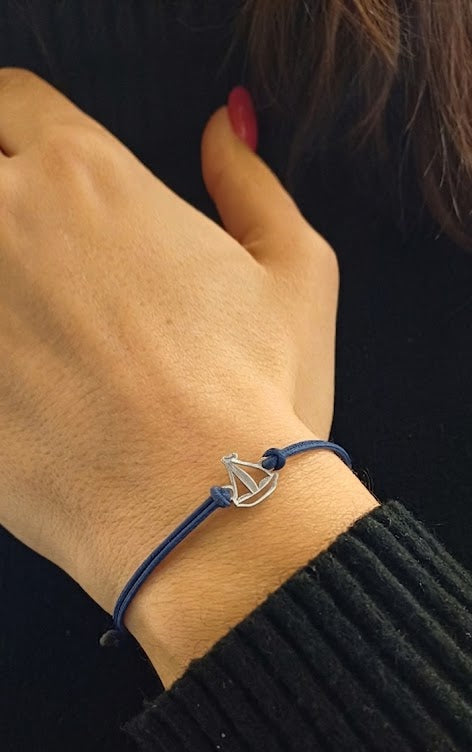 Bracciale con barca a vela in argento 925 su cordino blu regolabile, gioiello artigianale leggero ispirato al mare e alla libertà