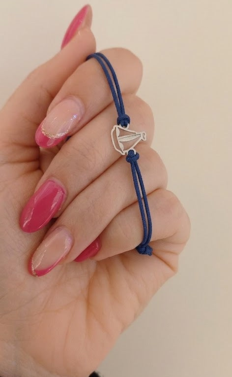 Bracciale con barca a vela in argento 925 su cordino blu regolabile, gioiello artigianale leggero ispirato al mare e alla libertà