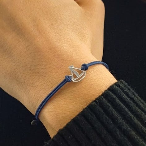 Bracciale barca a vela in argento 925 con cordino blu indossato al polso