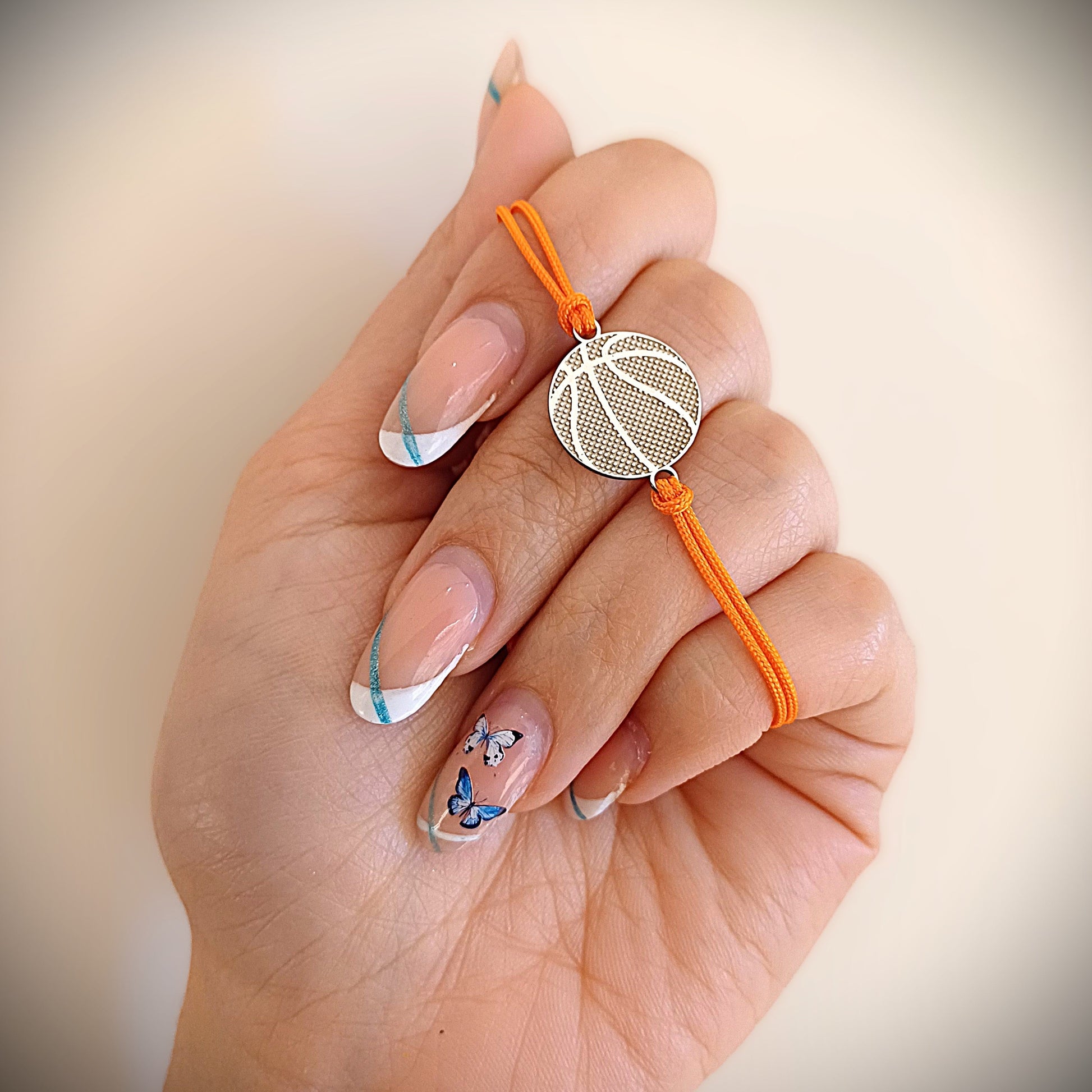 Bracciale con ciondolo tondo da 15 mm in argento 925 anallergico, raffigurante una palla da basket. Il retro del ciondolo è liscio e personalizzabile con una piccola dedica incisa. Il bracciale è adatto sia a uomini che donne, perfetto per chi ama lo sport o vuole fare un regalo con significato. La finitura è lucida, con linee ben definite e superficie morbida al tatto. Comodo da indossare ogni giorno, anche sulla pelle sensibile.