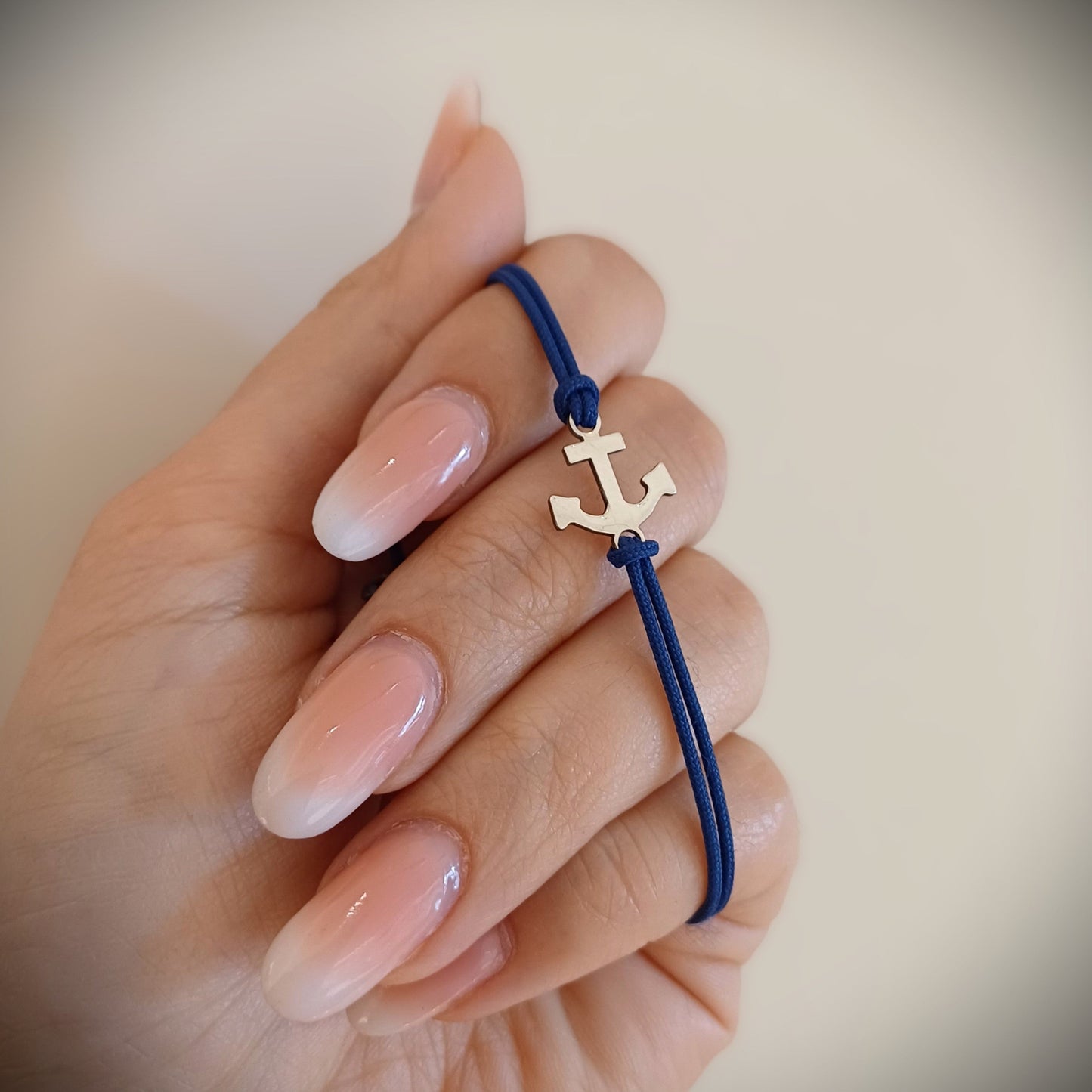 Dettaglio dell'ancora in argento 925 da 12 mm con cordino blu
