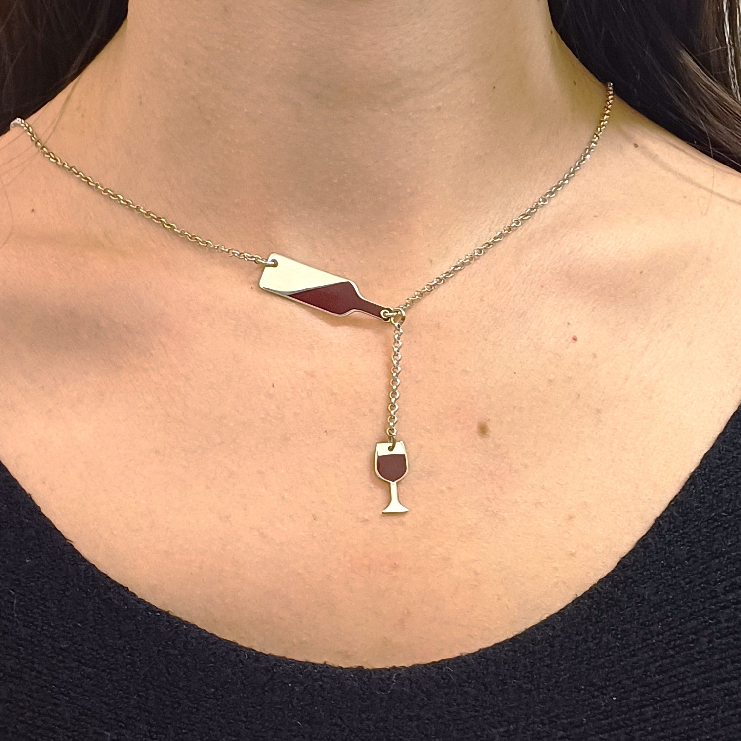 Questo girocollo della linea "Passioni" è un gioiello unico e realizzato a mano in argento 925 nel nostro laboratorio orafo a Livorno. Il design rappresenta una piccola bottiglia inclinata, da cui sembra versare il vino in un elegante bicchiere. Entrambi i ciondoli, bottiglia e bicchiere, sono smaltati in un profondo rosso bordeaux, creando un effetto realistico che richiama la passione per il vino. La catenina in argento è leggera, confortevole e si adatta ad ogni outfit