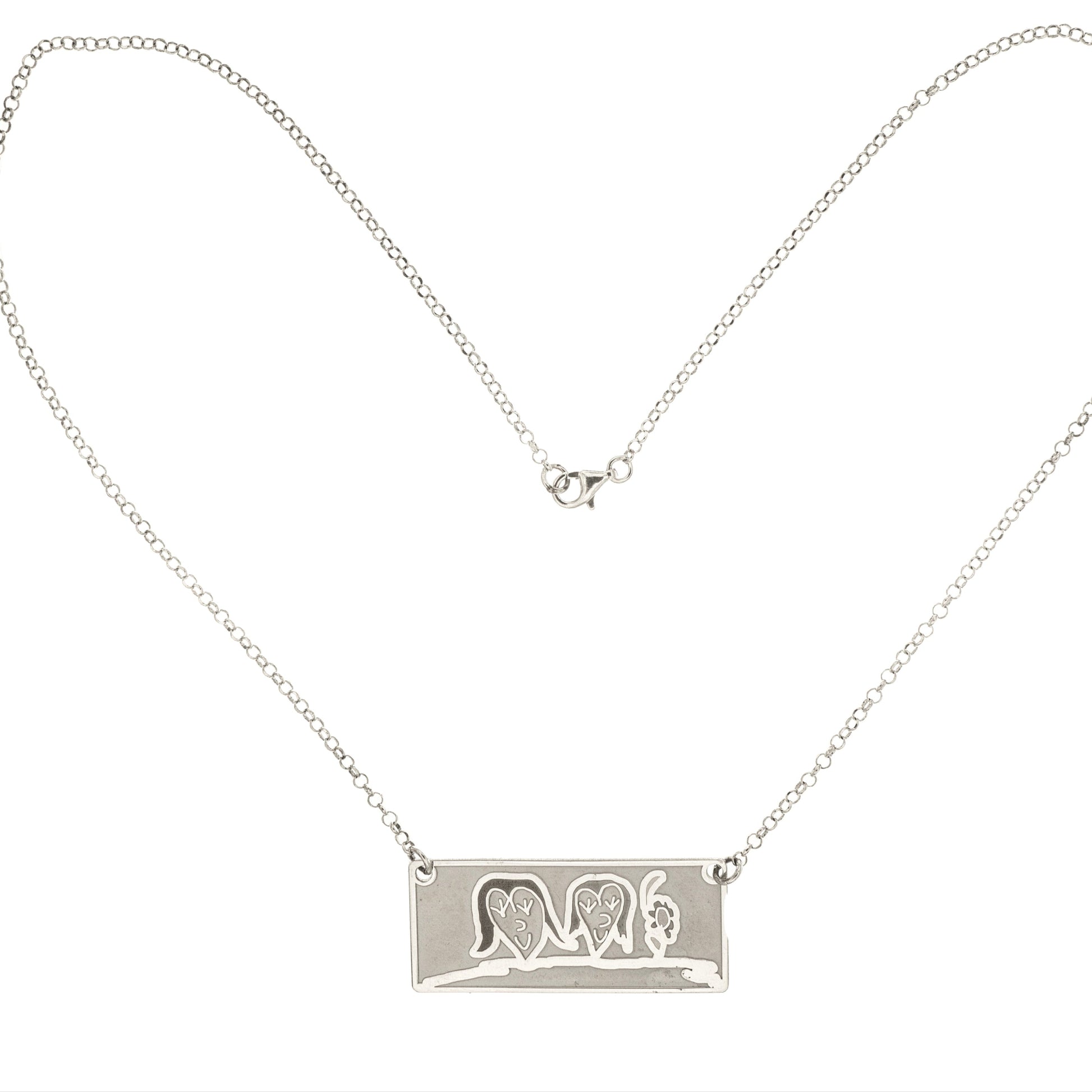 Girocollo in argento 925, con catena fine e leggera.
Al centro pende una targhetta piatta e lucida, grande circa 2,5 cm, di forma rettangolare.
Sulla superficie è inciso il disegno di un bambino, spesso fatto a mano su carta e poi fedelmente riportato sul metallo.
Il bordo è morbido e leggermente stondato, il tutto è liscio al tatto.
Il girocollo è leggero, con chiusura semplice e sicura. Si porta vicino al cuore.