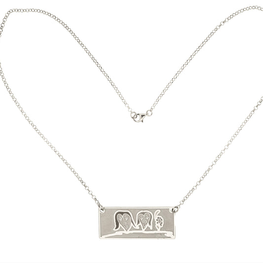 Girocollo in argento 925, con catena fine e leggera.
Al centro pende una targhetta piatta e lucida, grande circa 2,5 cm, di forma rettangolare.
Sulla superficie è inciso il disegno di un bambino, spesso fatto a mano su carta e poi fedelmente riportato sul metallo.
Il bordo è morbido e leggermente stondato, il tutto è liscio al tatto.
Il girocollo è leggero, con chiusura semplice e sicura. Si porta vicino al cuore.
