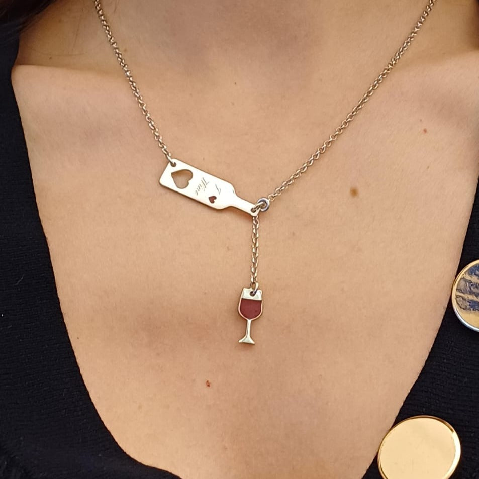 Questo girocollo in argento 925 è leggero e liscio al tatto, con due ciondoli dettagliati: una bottiglia slanciata e un bicchiere sottile. La scritta in rilievo "I Love Wine" si percepisce con le dita, dando un tocco di carattere al design. Il metallo è anallergico e piacevole sulla pelle. È possibile personalizzare il retro della bottiglia con un’incisione speciale, rendendolo un regalo unico per chi ama il vino e l’eleganza.