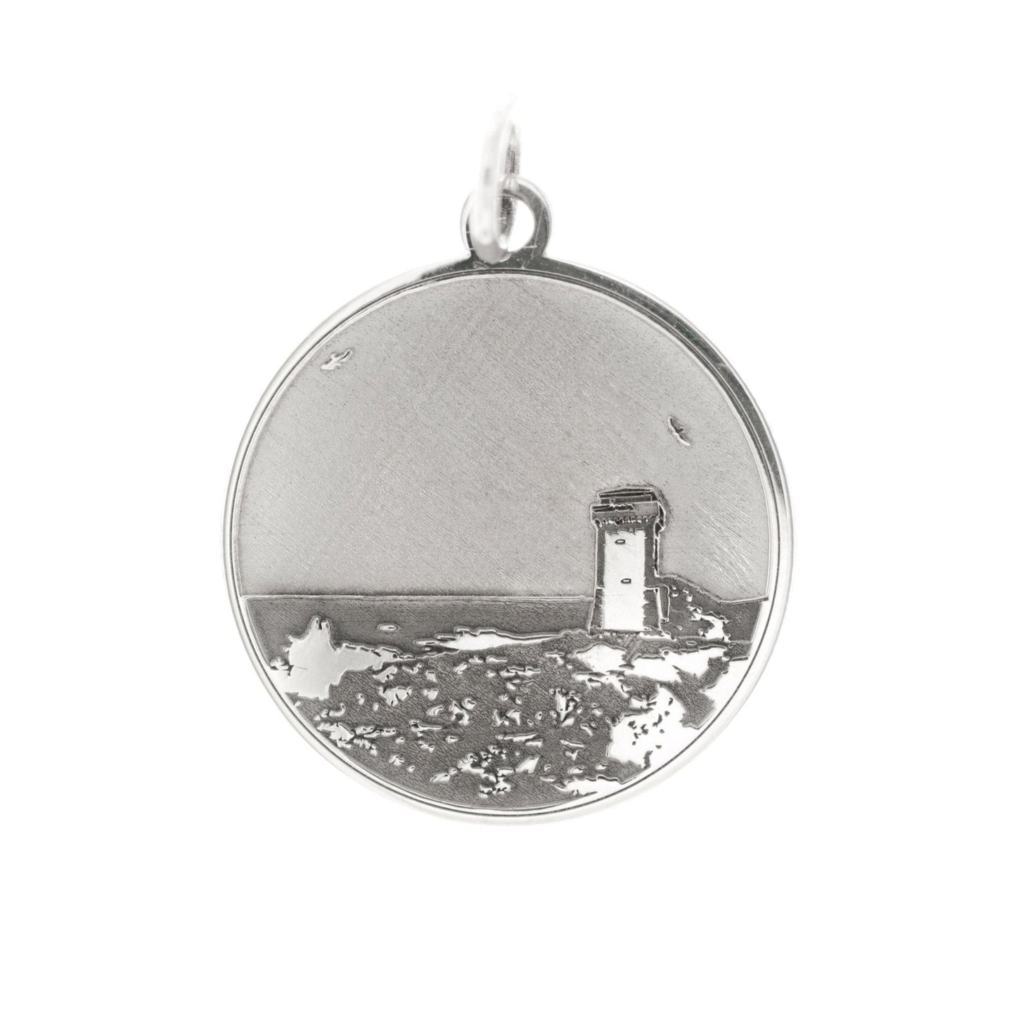 Questa è una medaglia in argento 925, rotonda e piatta, con un diametro di circa 20 mm. Sulla superficie è incisa la Torre di Calafuria, un faro storico situato sulla costa di Livorno. La torre è rappresentata in rilievo, con dettagli che mostrano il paesaggio circostante, come il mare e la scogliera. È un pezzo elegante e simbolico, pensato per celebrare un luogo iconico. La medaglia è dotata di un piccolo anello sulla parte superiore, che ne consente l'uso come ciondolo.