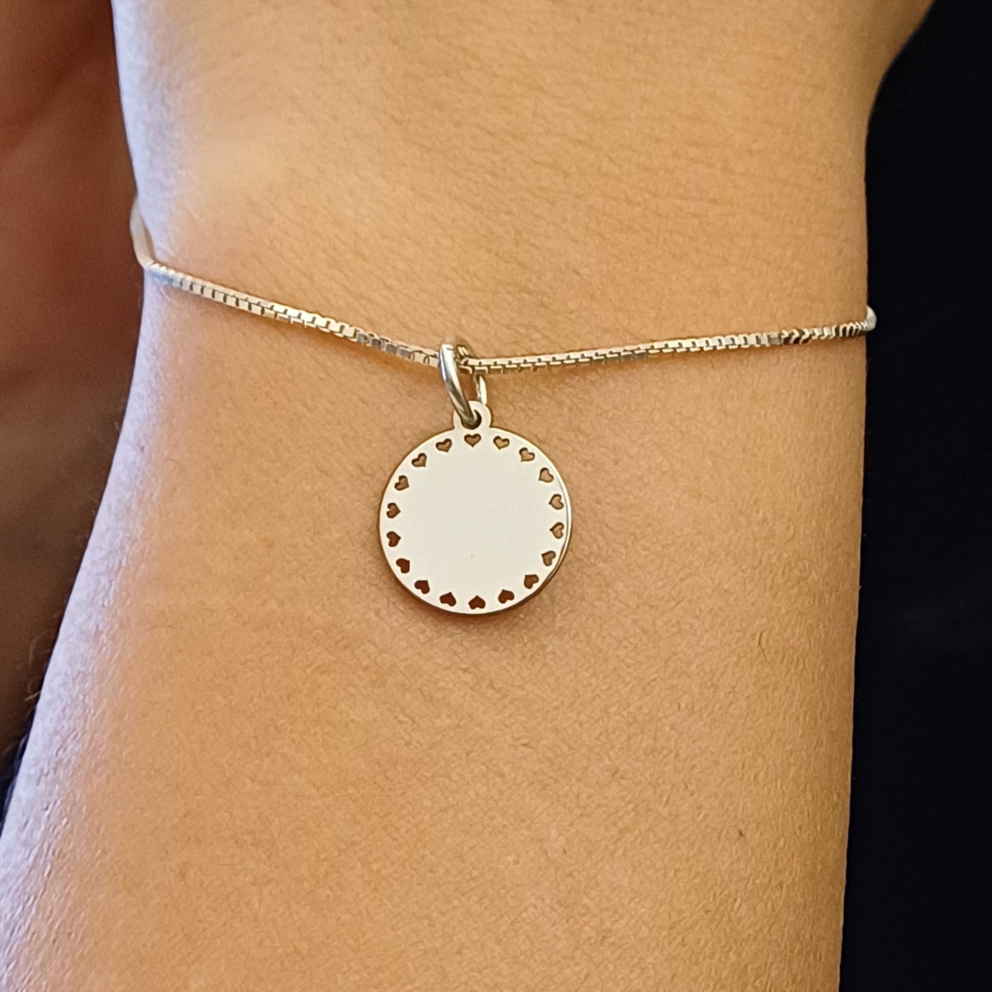 Questo pendente rotondo di 13 mm è decorato con piccoli cuori traforati lungo il bordo. Disponibile in oro Giallo, è stato creato con maestria artigianale nel nostro laboratorio orafo a Livorno. La superficie liscia e lucida è valorizzata da un’incisione laser precisa, rendendolo un pezzo unico e delicato. È un gioiello leggero, simbolico e versatile, perfetto per ogni stile e occasione.