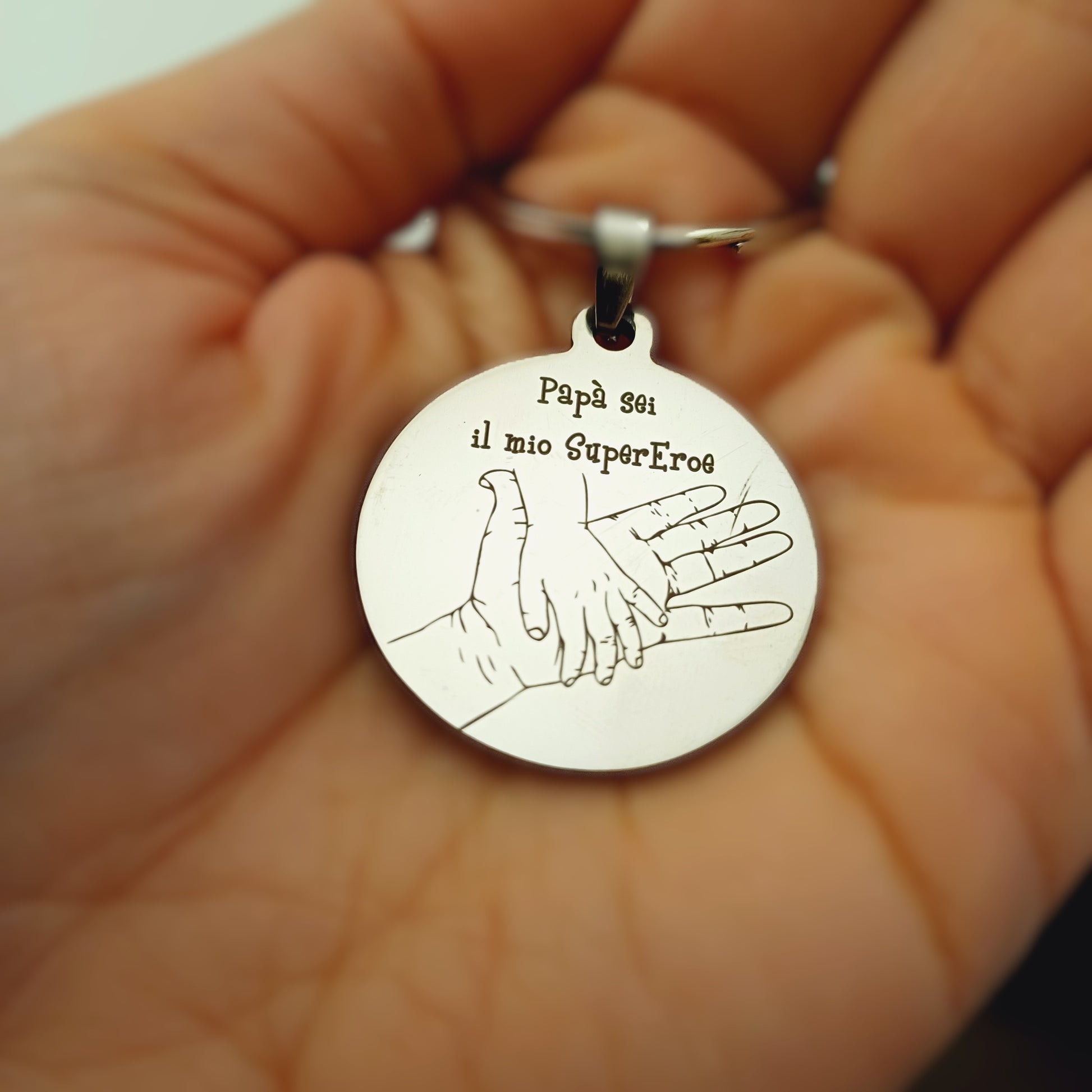 Un portachiavi rotondo, dal diametro di 30 mm, realizzato in acciaio resistente e piacevolmente liscio al tatto. Sulla sua superficie è incisa a laser un’immagine speciale, dedicata alla Festa del Papà. L’incisione è nitida e percettibile sotto le dita, creando un effetto leggermente ruvido che contrasta con la lucentezza del metallo. Solido ma leggero, è perfetto per accompagnare ogni giorno il papà che lo riceverà in dono. Personalizzabile con un nome o una frase speciale.