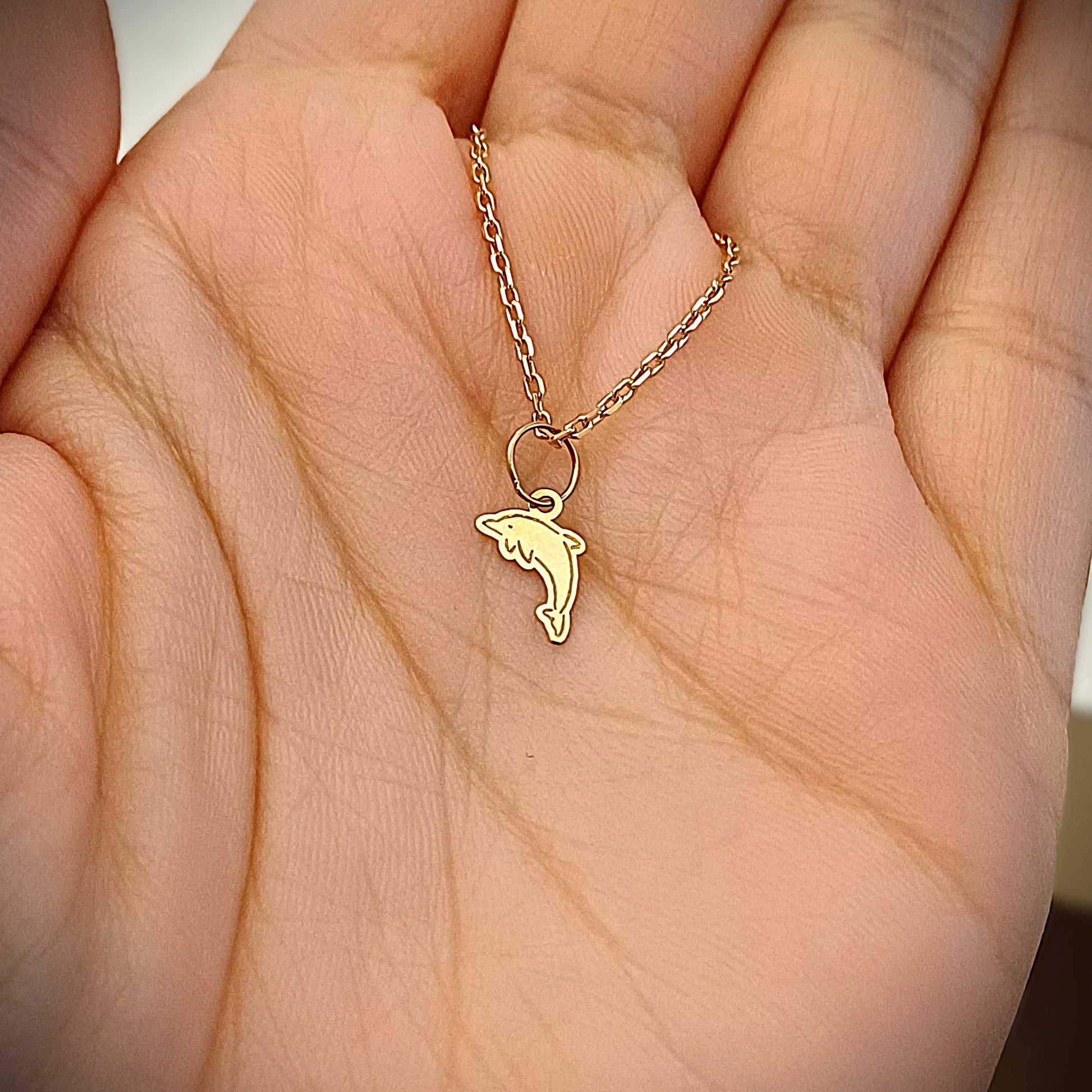 Questo ciondolo è piccolo e leggero, alto appena 9 millimetri, con la forma di un delfino stilizzato in volo, dal profilo morbido e armonioso. È realizzato in argento 925 o in oro 18 carati, a scelta. Il metallo è lucido, liscio al tatto, con leggere incisioni che delineano i tratti del muso e delle pinne. Ogni pezzo è realizzato a mano, con amore, nel nostro laboratorio artigianale. È un gioiello semplice ma ricco di significato.