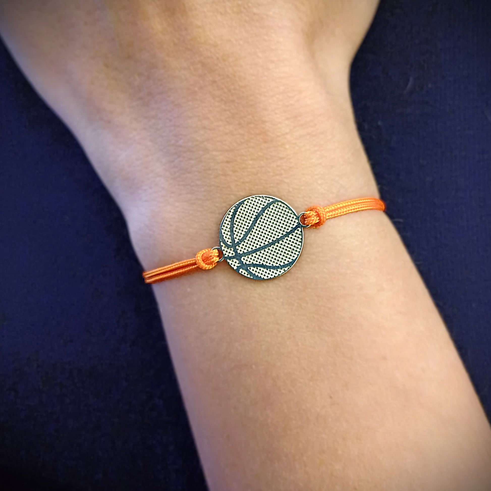 Bracciale basket in argento 925 indossato su mano con cordino arancione