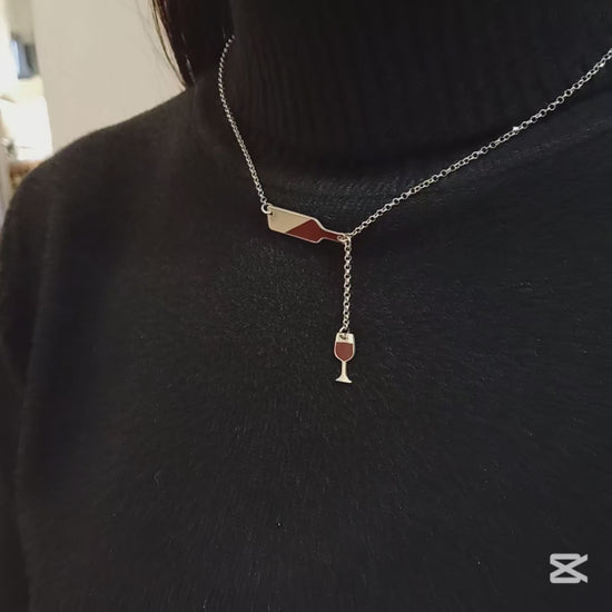 Questo girocollo della linea "Passioni" è un gioiello unico e realizzato a mano in argento 925 nel nostro laboratorio orafo a Livorno. Il design rappresenta una piccola bottiglia inclinata, da cui sembra versare il vino in un elegante bicchiere. Entrambi i ciondoli, bottiglia e bicchiere, sono smaltati in un profondo rosso bordeaux, creando un effetto realistico che richiama la passione per il vino. La catenina in argento è leggera, confortevole e si adatta ad ogni outfit