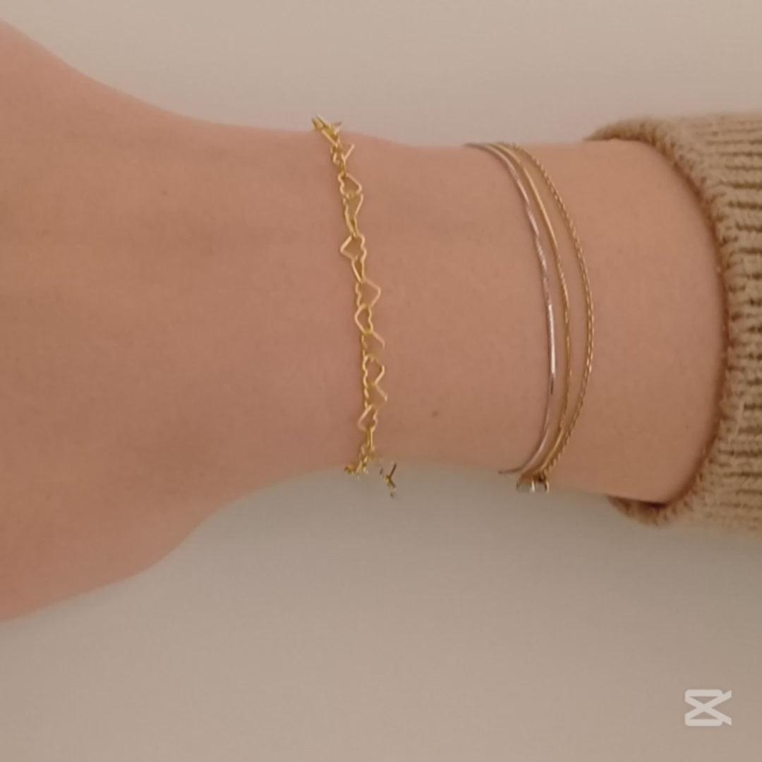 Immagina un bracciale delicato e leggero, composto da una fila di piccoli cuori, questo bracciale è realizzato con un sottile filo d’argento, lucido e liscio al tatto. Il design è semplice ma ricco di significato, ideale per chi ama dettagli raffinati e romantici. Il bracciale, venduto dal nostro laboratorio orafo a Livorno, scivola dolcemente sul polso, regalando una sensazione di leggerezza e una carezza che accompagna ogni movimento.
