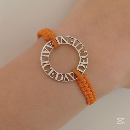 Immagina un cerchio liscio e leggero, con nomi traforati che emergono come piccole sculture tra il vuoto e la luce. Ogni lettera è incisa con precisione, creando un contrasto tra il metallo freddo e il calore del cordino intrecciato a mano, morbido e avvolgente sul polso. La superficie è liscia, con bordi definiti ma delicati al tatto. Questo bracciale personalizzato è un abbraccio in argento, con parole che parlano di affetti, ricordi e connessioni profonde.