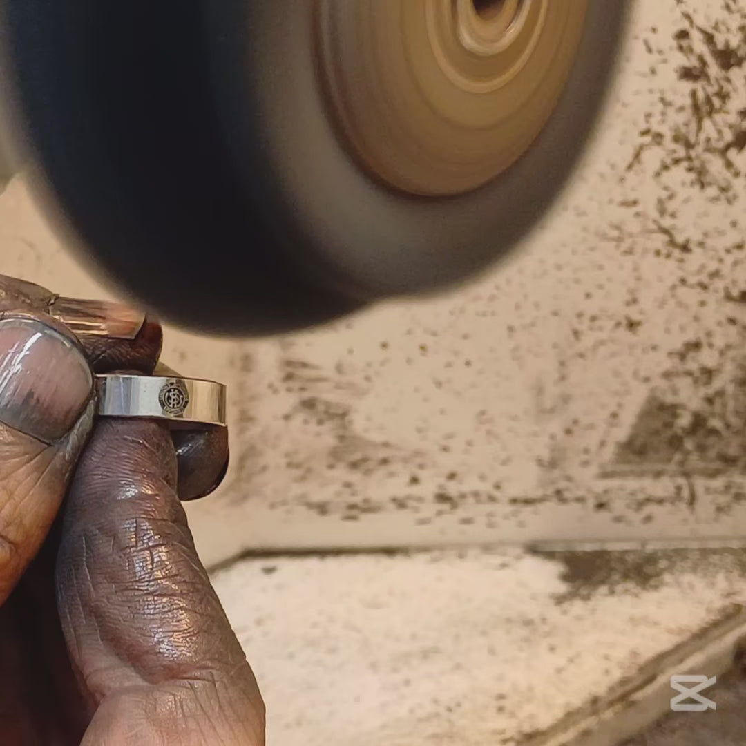 Immaginati un anello dalla forma semplice e robusta. La sua fascia, larga 5  millimetri, avvolge il dito con un tocco deciso. La superficie, liscia e lucida, è interrotta da un'incisione smaltata: il logo dell'U.S. Livorno. Un gioiello realizzato a mano nel nostro laboratorio orafo, perfetto per chi vuole mostrare con orgoglio la propria passione per i colori amaranto. Un pezzo unico, personalizzabile e resistente, creato appositamente per te.