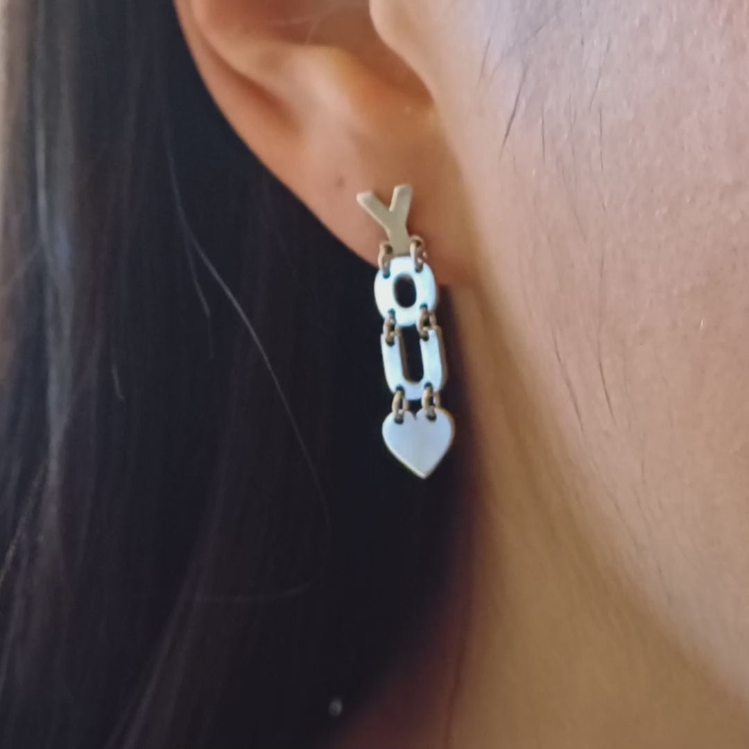 Gli orecchini sono pendenti e mobili, composti da lettere snodabili che formano la scritta "I LOVE YOU". Sono realizzati in argento liscio e brillante, con un design elegante e leggero. Grazie ai piccoli snodi tra le lettere, si muovono delicatamente ad ogni passo, creando un effetto dinamico e raffinato. Perfetti per chi ama gioielli con significato, esprimono un messaggio romantico e universale, da indossare con leggerezza e stile.