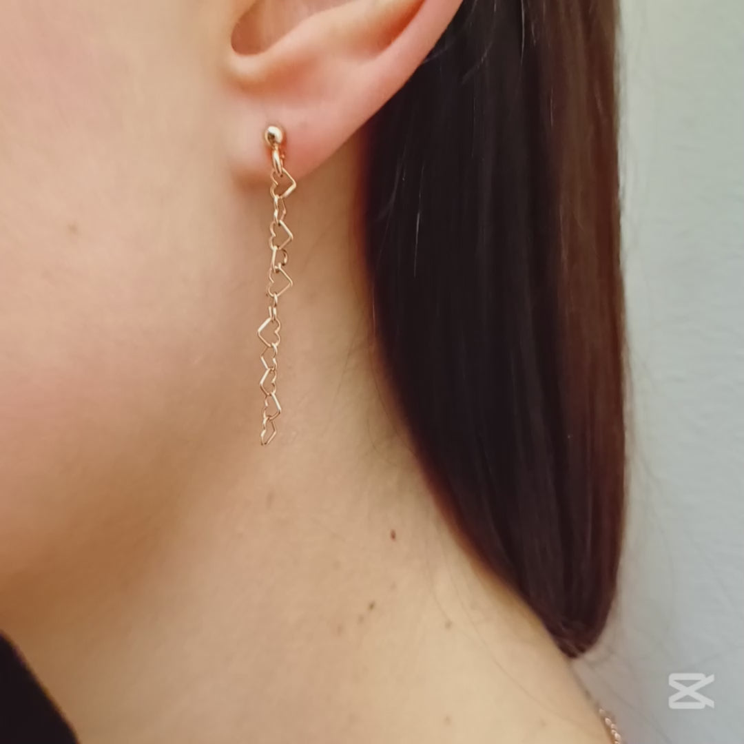 Questi orecchini pendenti sono realizzati in argento 925 nelle varianti Rodiato, Dorato e Ramato e presentano una catena leggera formata da piccoli cuori vuoti collegati tra loro. Il design è arioso e delicato, con una cascata sottile che ondeggia dolcemente con ogni movimento. La chiusura è a perno con farfallina, pratica e sicura. Il colore è un caldo oro giallo lucido, che riflette la luce in modo raffinato. Perfetti per chi ama i dettagli romantici e sofisticati.