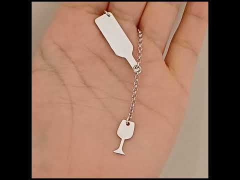 Questo girocollo della linea "Passioni" è un gioiello unico e realizzato a mano in argento 925 nel nostro laboratorio orafo a Livorno. Il design rappresenta una piccola bottiglia inclinata, da cui sembra versare il vino in un elegante bicchiere. Entrambi i ciondoli, bottiglia e bicchiere, sono smaltati in un profondo rosso bordeaux, creando un effetto realistico che richiama la passione per il vino. La catenina in argento è leggera, confortevole e si adatta ad ogni outfit, regalando un tocco di stile person