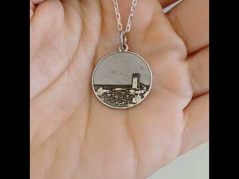 Questa è una medaglia in argento 925, rotonda e piatta, con un diametro di circa 20 mm. Sulla superficie è incisa la Torre di Calafuria, un faro storico situato sulla costa di Livorno. La torre è rappresentata in rilievo, con dettagli che mostrano il paesaggio circostante, come il mare e la scogliera. È un pezzo elegante e simbolico, pensato per celebrare un luogo iconico. La medaglia è dotata di un piccolo anello sulla parte superiore, che ne consente l'uso come ciondolo.
