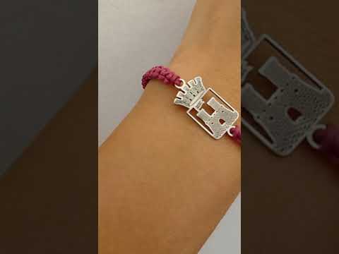 Il braccialetto è realizzato in sagolino marino amaranto e bianco, annodato in un motivo elegante. Al centro c'è il "FIDES" in argento, lo stemma di Livorno ,alto 25mm. Il braccialetto è regolabile, quindi può essere indossato da chiunque. dettaglio foto in bianco

